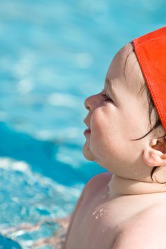 cute happy baby smiling at swimming pool during summer
