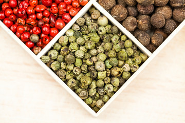 Spices and black rice in a wooden box: red, green and white pepper, sea salt, himalayan salt, allspice and coriander