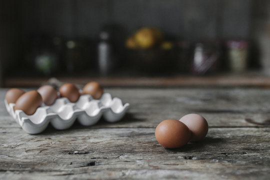 Fresh hen's eggs in a box and on a wooden table. 