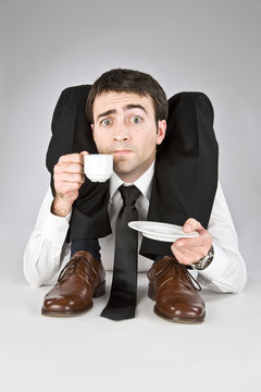 flexible businessman with doubtful face isolated on white drinking coffee