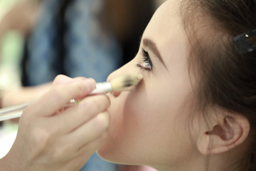  Little girl applying make up.