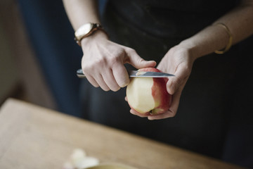 A woman peeling an apple with a knife