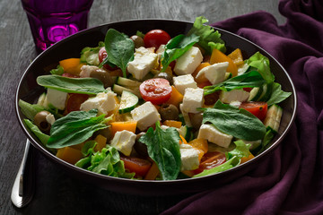 Fresh greek salad with Feta and vegetables on purple plate