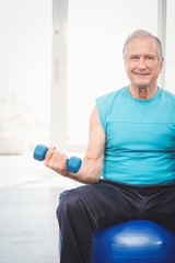 Portrait of senior man holding dumbbell