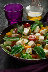 Fresh greek salad with Feta and vegetables on purple plate