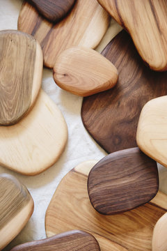 A collection of small smooth turned wooden objects of different colours and wood grain patterns. 