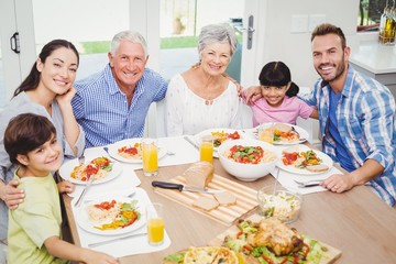 Portrait of smiling multi generation family with arm around 