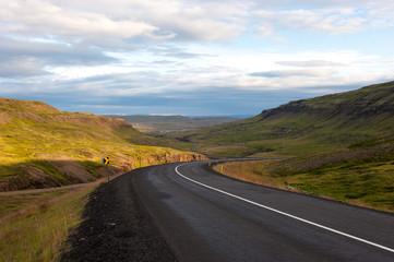 Landscape with mountains and meandering road at sunset, Iceland