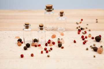 Spices and empty, small glass bottles with wooden texture