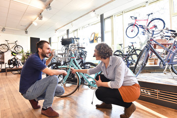 Verkaufsgespräch im Fahrradladen - Verkäufer berät Kundin beim Fahrradkauf // bike shop - seller...