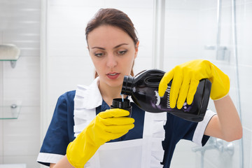 Housekeeper measuring out detergent from a bottle
