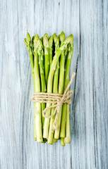 Green fresh asparagus on light painted wooden background