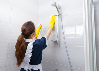 Housekeeper cleaning the shower head