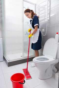 Hardworking hotel employee mopping the floor