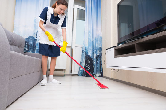Maid or housekeeper cleaning a living room