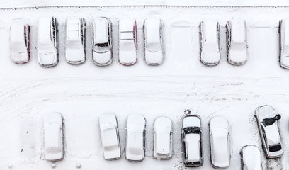 Long parking lot at winter season with cars covered with snow, top view © Kekyalyaynen