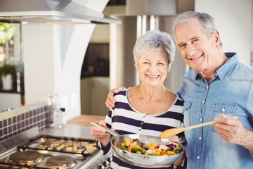 Portrait of happy senior couple with cooking pan