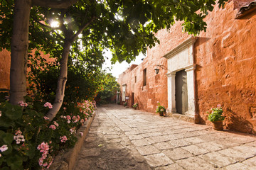 red buildings and garden with flowers in arequipa monastery - obrazy, fototapety, plakaty