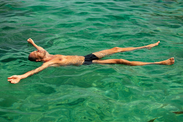 homme dans l'eau cristalline qui fait la planche 