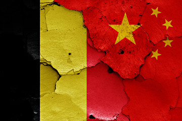 flags of Belgium and China painted on cracked wall