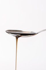 
    spoon pouring a liquid. Isolated on a white background. Pharmacy and healthy background. Medicine. Cough and cold drug. 