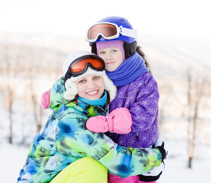 smiling woman and little girl at the ski resort