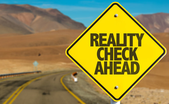 Reality Check Ahead sign on desert road