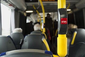 Fototapeta premium Yellow handrail on the bus with stop button