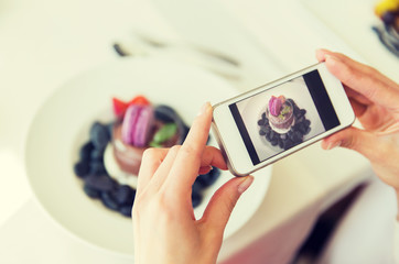close up of woman picturing food by smartphone