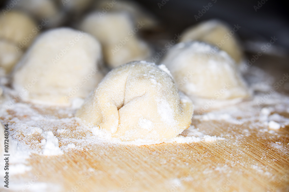 Wall mural uncooked homemade pelmeni lies on a flour