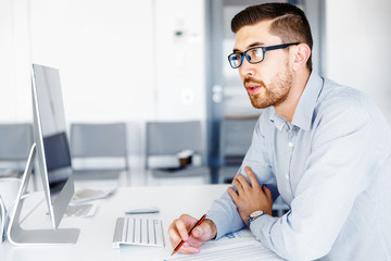 Fototapeta premium Male office worker sitting at desk