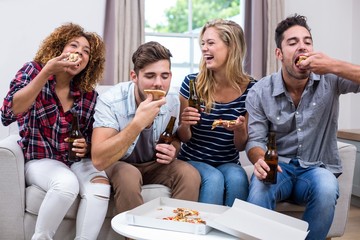 Cheerful young friends enjoying pizza