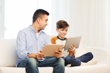 happy father and son with tablet pc at home