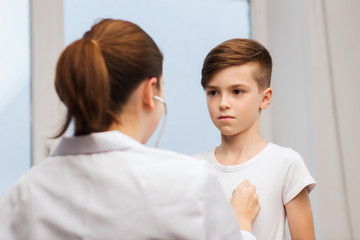 Obraz na płótnie Canvas doctor with stethoscope listening to child