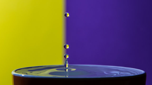 Gocce d'acqua in tazza su sfondo bicolore