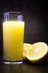 Cuted lemon and glass with dissolvable vitamins in dark ambient 