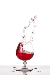 Mandarino tuffato in bicchiere da aperitivo con liquido arancione