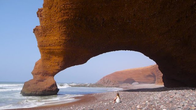 Girl resting near arcs on Legzira beach
