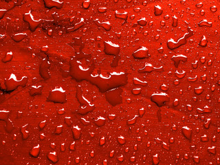 water drops on red metallic surface