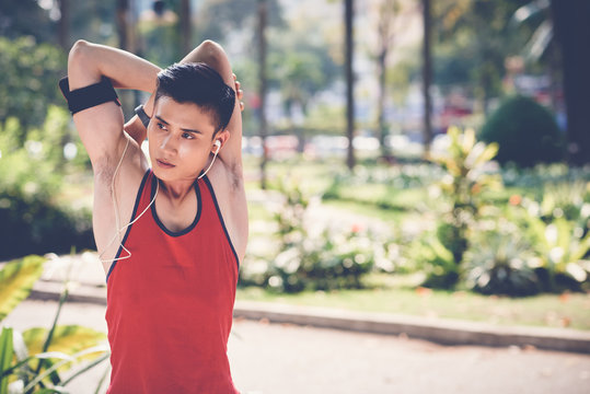 Handsome fit man stretching arms after workout