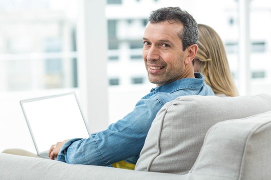 Couple sitting together and using laptop