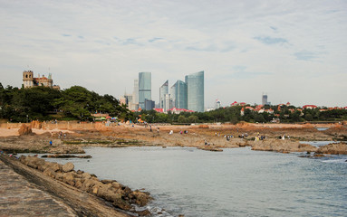 Naklejka premium Badaguan Scenic area with Huashi Lou villa and Shinan district skyscrapers in the background QIngdao, China