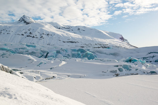 Svinafellsjokull glacier tongue in winter, blue icebergs covered by snow, Iceland