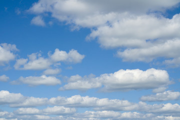White heap clouds in the blue sky. Cloudscape over horizon.