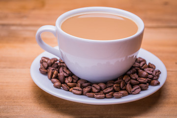 Coffee cup and saucer on a wooden table. Dark background.