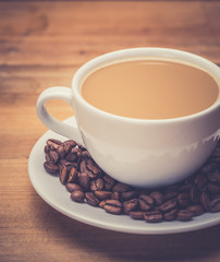 Coffee cup and saucer on a wooden table. Dark background.