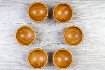 Top view of wooden bowl on wooden background