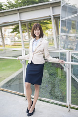 Attractive asian business woman smiling outside office