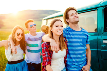 Young frieds with campervan, green nature and blue sky