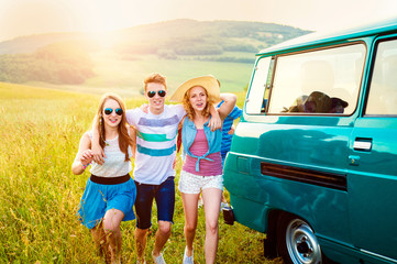 Young frieds with campervan, green nature and blue sky